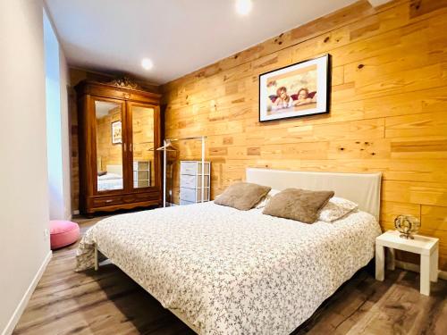 Gîte de campagne Gaspard的一间卧室设有一张床和木墙