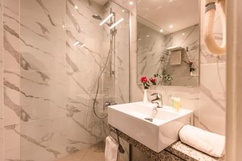 安曼丽湾酒店的带淋浴和盥洗盆的白色浴室