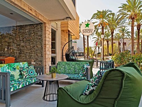 罗德镇STAY Rhodes Hotel的一个带绿色椅子和停车标志的庭院
