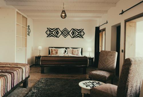 达赫拉Les Dunes de Dakhla的配有一张床和一把椅子的酒店客房
