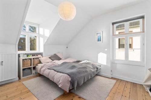 哥本哈根Rooms in quiet white villa apartment Hortensiavej 8 on Frederiksberg C的一间白色卧室,配有床和2个窗户