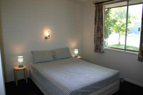 布赖特阿格里度假公寓的一间卧室配有一张床和两张台灯。