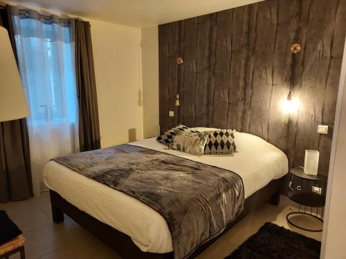 PrudhomatAu Vieux Séchoir的一间卧室设有一张带木墙的大床