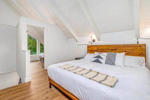 洋滨市Tidal House 6的卧室配有一张白色大床和木制床头板