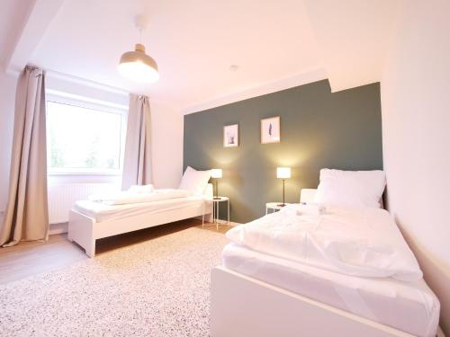 奥斯纳布吕克75 m2, zentral, Küche, Balkon, Parkplatz的带窗户的客房内的2张白色床