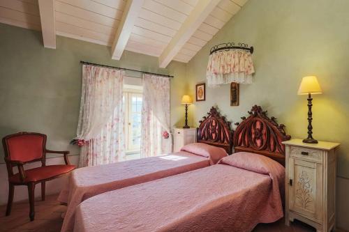 卡麦奥雷Villa Melangola的一间卧室设有两张床、一把椅子和一个窗户。