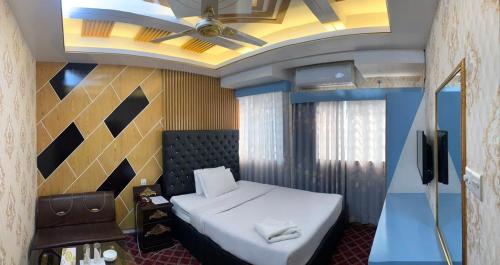 达卡Hotel Heaven Inn的一间卧室配有一张床和吊扇