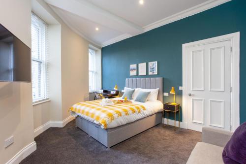 爱丁堡Royal 2bed apartment City Center的一间卧室设有一张床和蓝色的墙壁