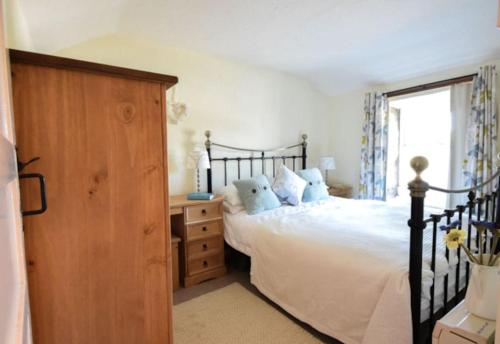 海尔Water's View Cottage, Hayle的一间卧室配有一张床、一个梳妆台和一扇窗户。