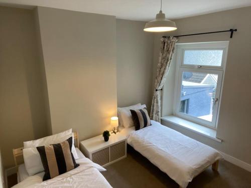 CwmcarnNewly renovated, hi-spec three bed, forest view home的一间卧室设有两张床和窗户。
