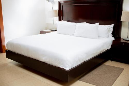 布兰太尔Krisstar Lodge的一张大白色的床,位于酒店客房内