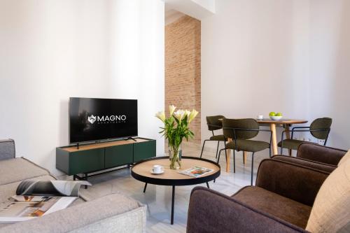 塞维利亚Magno Apartments San Gil - Shared Jacuzzi的带沙发和电视的客厅