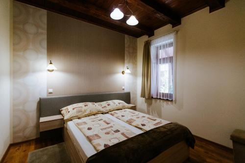 莫劳豪洛姆Németh Apartmanházak的一间卧室设有一张床和一个窗口