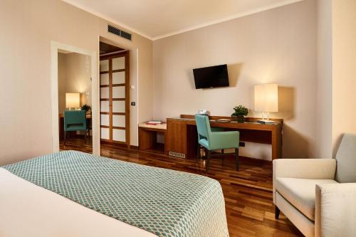 芬奇达芬奇酒店的酒店客房配有一张床、一张书桌和一张沙发。