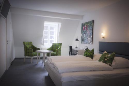 厄斯特里希-温克尔Hotel Schwan的卧室配有一张床和一张桌子及椅子