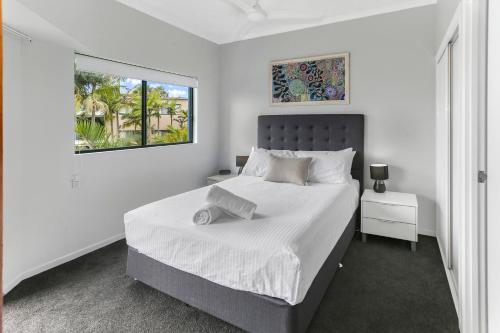 卡伦德拉Unit 41 at Portobello Dicky Beach的白色的卧室设有一张大床和一个窗户