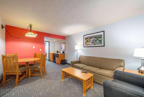 苏福尔斯Ramada by Wyndham Sioux Falls Airport - Waterpark Resort & Event Center的客厅配有沙发和桌子