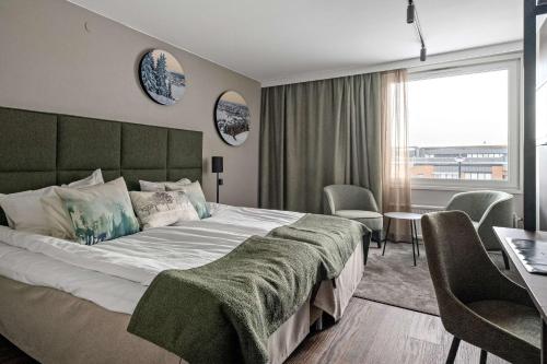 厄斯特松德贝斯特韦斯特艾特酒店的一间卧室配有一张大床和一张桌子及椅子
