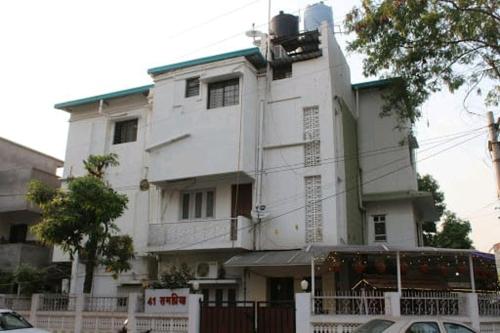 那格浦尔Rampriya Service Apartment的前面有标志的大型白色建筑