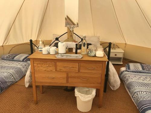 特鲁罗Cox Hill Glamping Badger的一间设有桌子和两张床的房间以及帐篷