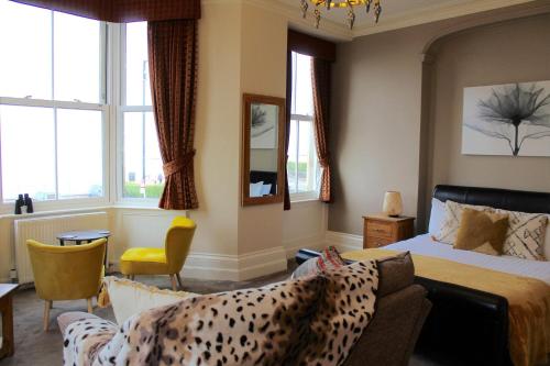 莫克姆皇冠酒店的一间卧室配有一张床、一张沙发和窗户。