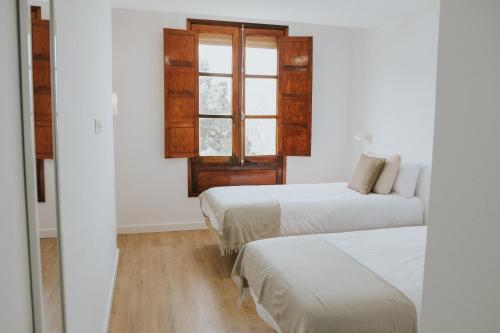 克鲁兹·德·特赫达Texeda Room Suites的客房设有两张床和窗户。
