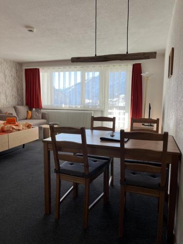 洛伊克巴德Haus Atlantic Leukerbad的客厅配有桌子和两把椅子