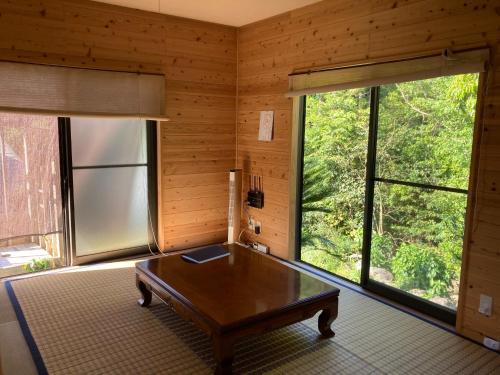 屋久岛Eco Lodge Moss Tasha - Vacation STAY 39871v的客厅设有桌子和大窗户