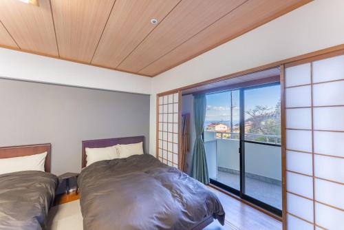 热海VIVI熱海 自然郷 3001丨VIVI Atami Shizenkyo 3001的一间卧室设有两张床和大窗户