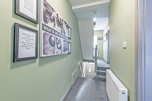普雷斯科特Luxury 5 Bedroom Holiday Home Within Prescot的走廊上设有楼梯,墙上挂有图片