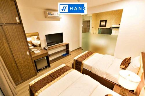 胡志明市HANZ MyMy Hotel Saigon的一间酒店客房,设有两张床和电视