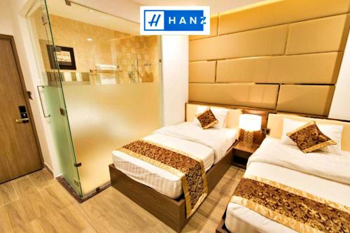 胡志明市HANZ MyMy Hotel Saigon的酒店客房设有两张床和一个标有字样的标志