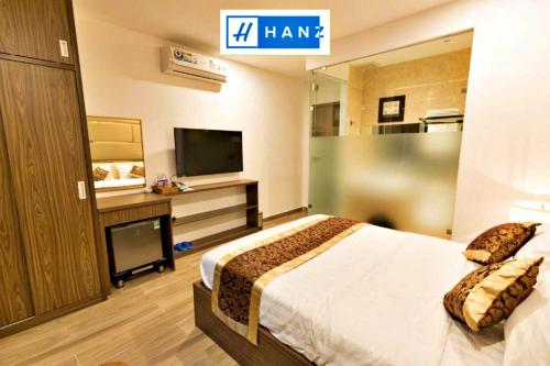 胡志明市HANZ MyMy Hotel Saigon的配有一张床和一台平面电视的酒店客房