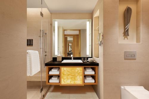 西隆Courtyard by Marriott Shillong的一间带水槽和镜子的浴室