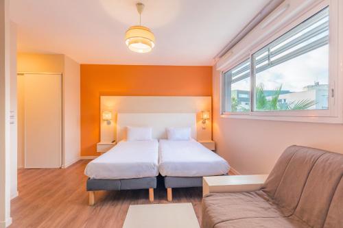 蒙彼利埃蒙彼利埃欧弗利I号城市舒适公寓式酒店的一间卧室配有一张床和一张沙发