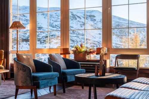 塞拉内华达The Mountains Hotel的配有椅子和桌子以及大窗户的房间