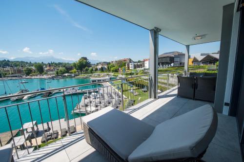 沃尔特湖畔韦尔登Boutiquehotel Wörthersee - Serviced Apartments的阳台配有沙发,享有码头的景色