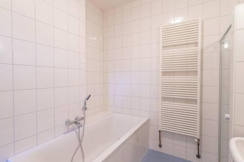 聚特芬De Dekenije的白色的浴室设有浴缸和水槽。