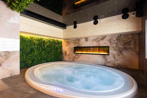 考斯赛力克Tatry Residence SPA的带壁炉的客房内的按摩浴缸