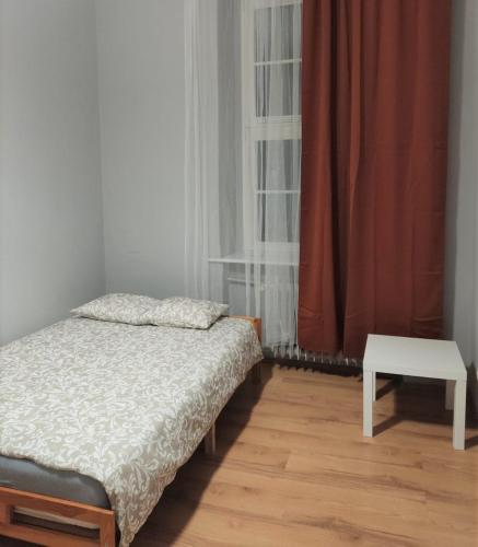 波兹南Rynek 7的一间小卧室,配有一张床和一张桌子