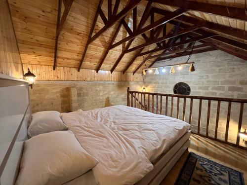 伊斯梅尔雷Lakeside Garden - Ismayilli Guest house的木制天花板的客房内的一张大床