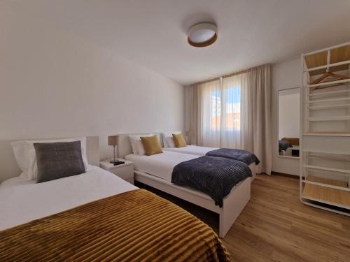 丰沙尔Funchal Downtown Flats 2的酒店客房设有两张床和窗户。
