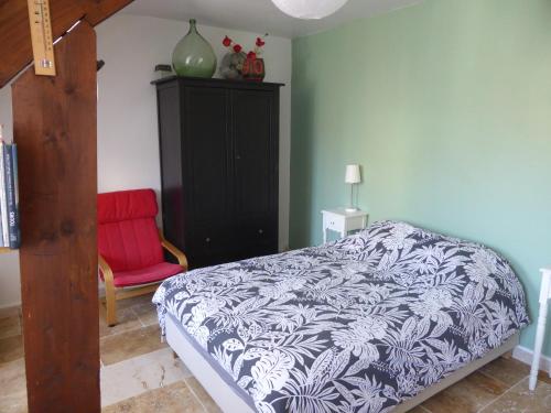图尔Studio calme au coeur de Tours的一间卧室配有一张床和一张红色椅子