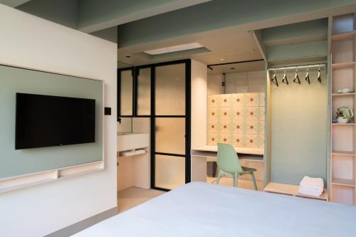 切塞纳蒂科Le stanze di Caterina的一间卧室配有电视和绿椅