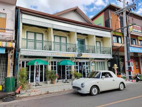 That PhanomSangthong Heritage hotel โรงแรมแสงทองเฮอริเทจ的停在大楼前的白色汽车