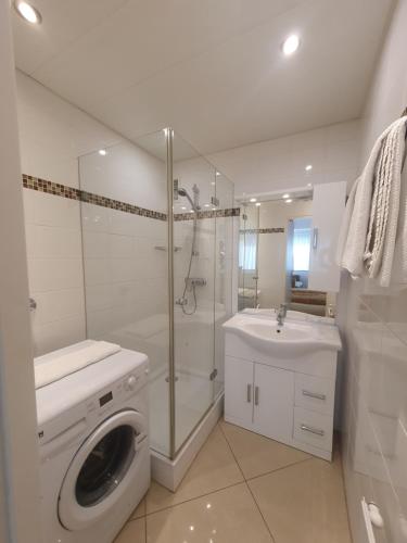 维也纳Central City Apartment Vienna的白色的浴室设有洗衣机和水槽。