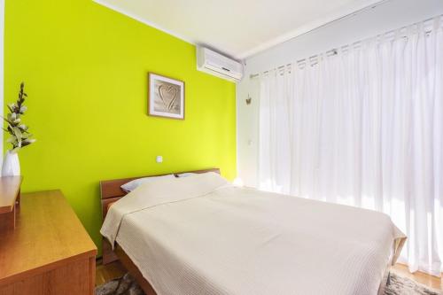 卡里高多Apartment Carigo的一间卧室设有绿色的墙壁、一张床和一张书桌