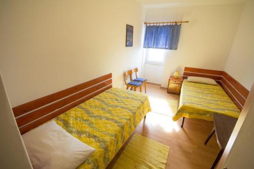 诺维格勒伊斯特拉Apartment Bencic的一间小卧室,配有两张床和椅子