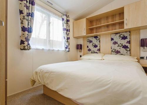 查茅斯Seadown Park的卧室设有一张白色大床和一扇窗户。