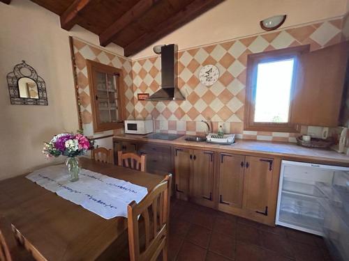 阿维拉Casa Rural Amarilla的厨房配有一张桌子,上面放着花瓶